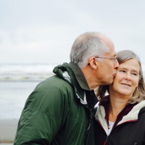 Older couple kissing on beach