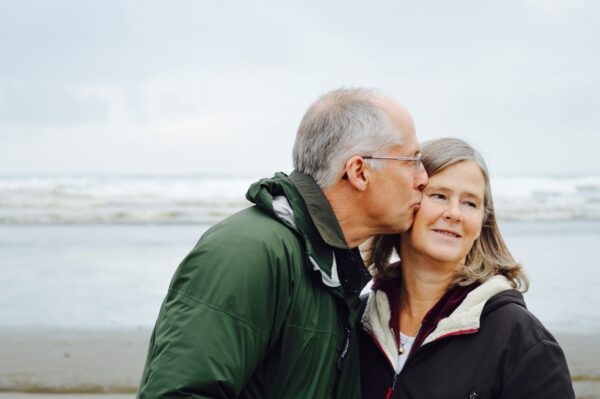 Older couple kissing on beach