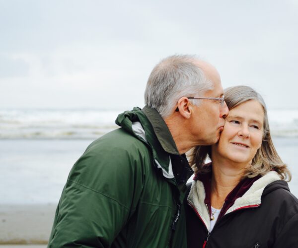 Older couple kissing on beach